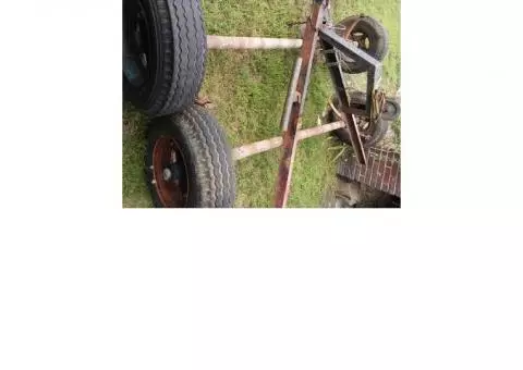 Two trailer axles with tires and rims and tongue